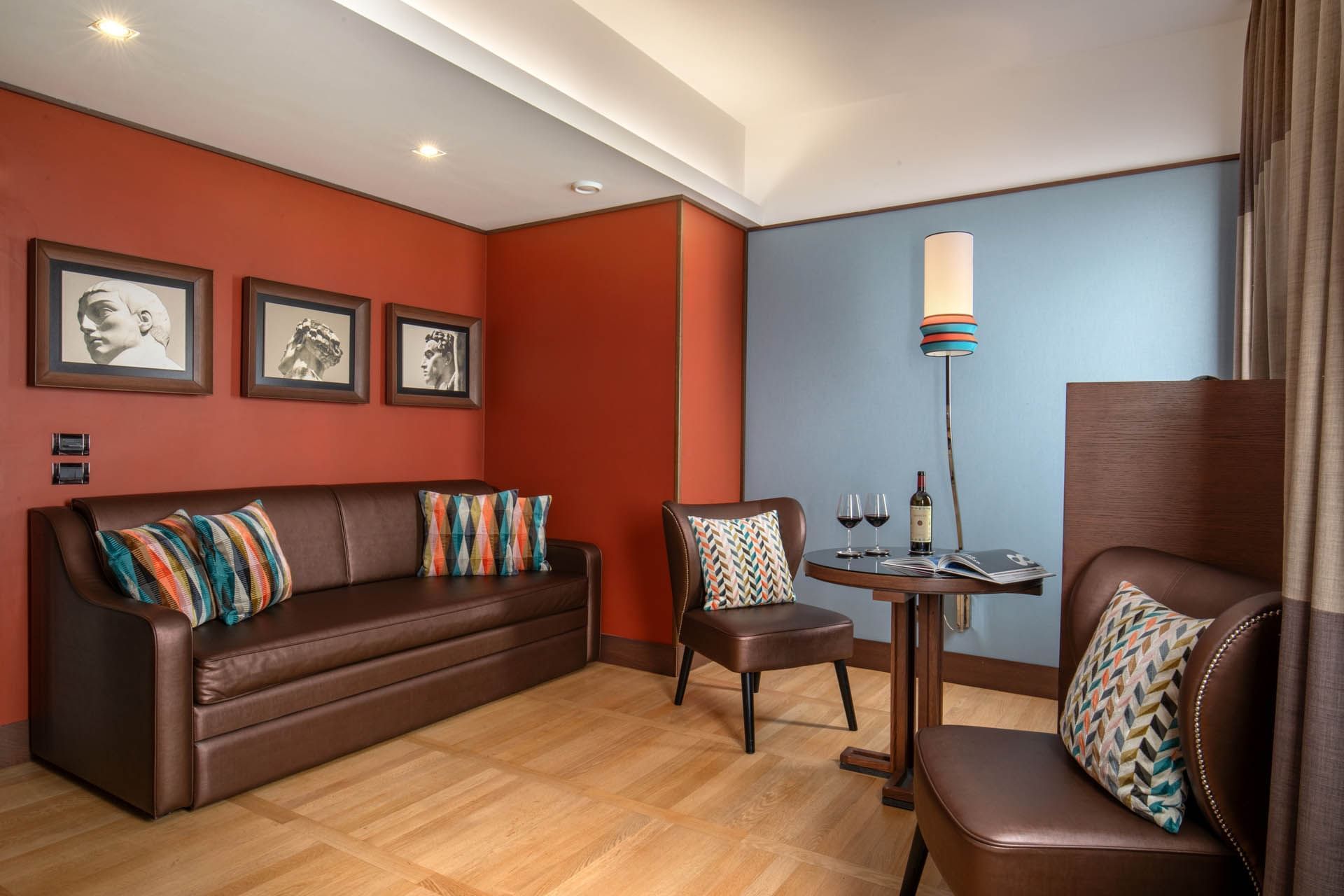 Cozy Cielo Suite lounge at The Independent with leather sofa, wine glasses, and modern lighting