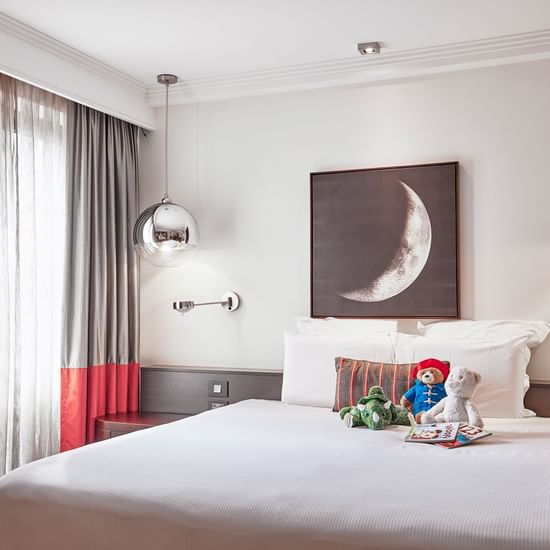 Queen bed and hanging chandeliers in Deluxe Suite at Pullman Albert Park