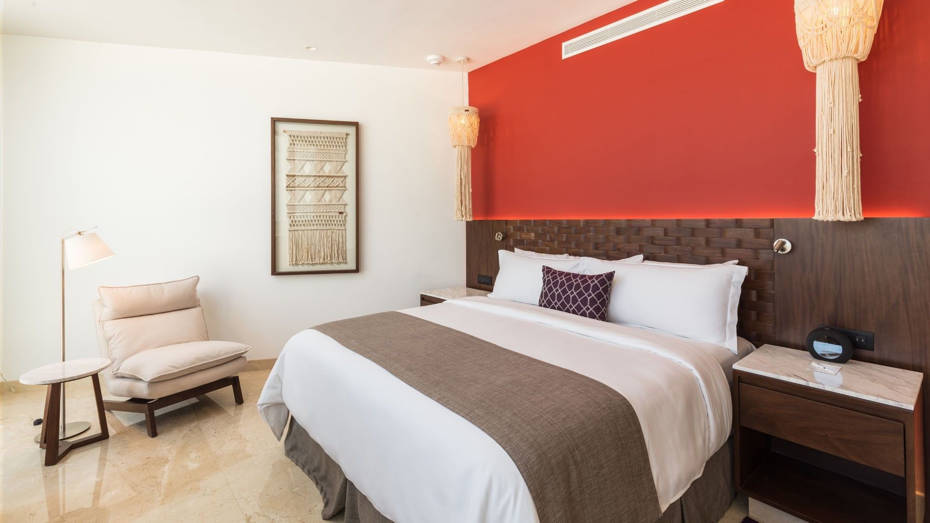 King Camino Real Club featuring a vibrant red accent wall and elegant bohemian light fixtures at Camino Real Merida