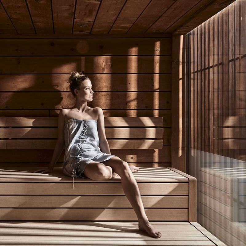 A lady relaxing in a sauna at Falkensteiner Hotels