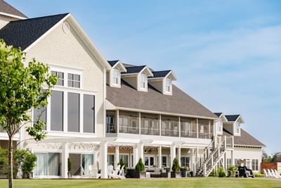 Exterior view of a large white resort building with a lawn at Rodd Crowbush Golf & Beach Resort
