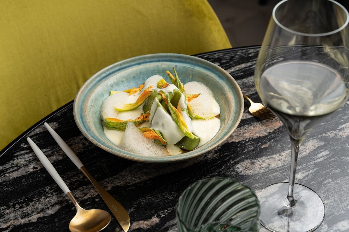 Table setting with dish in a bowl & wine in Virens Restaurant at Almanac Barcelona