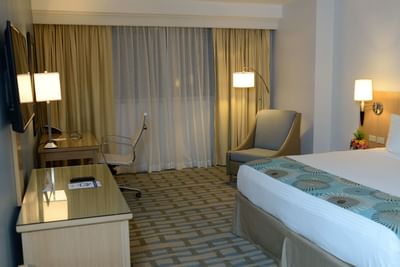 room with bed, desk and accent chair