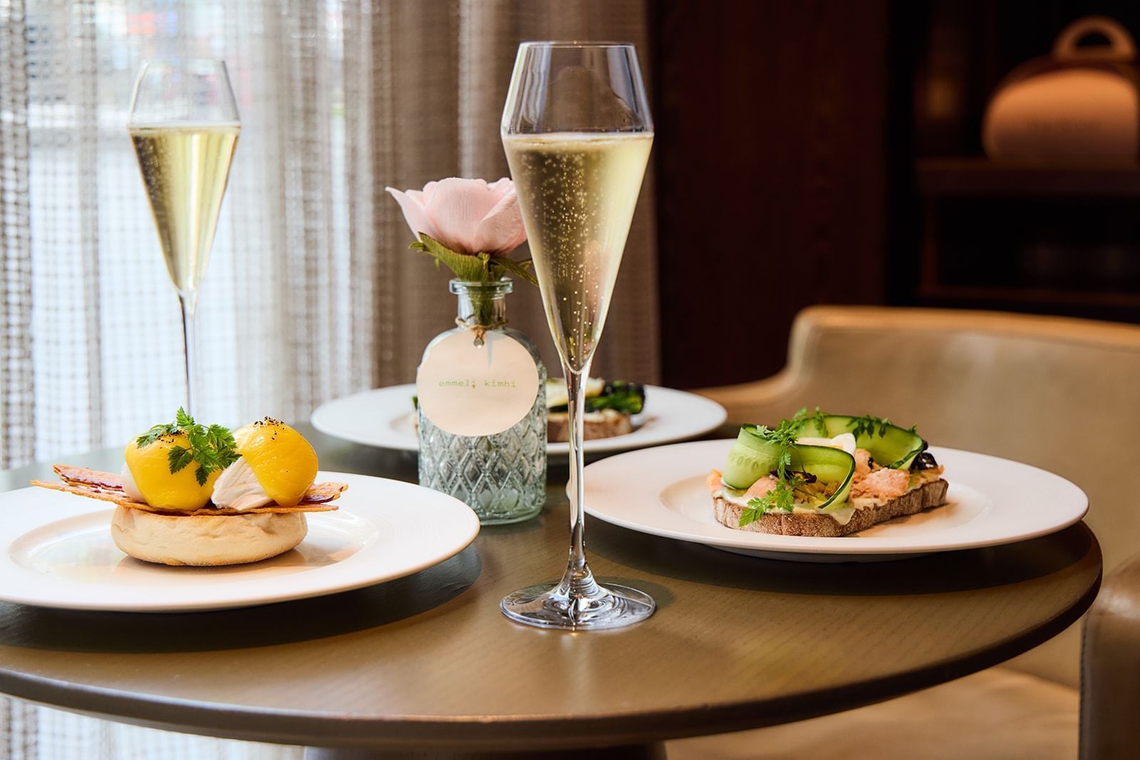 A delicious breakfast spread with eggs benedict, open-faced sandwiches, and champagne flutes at The Londoner Hotel