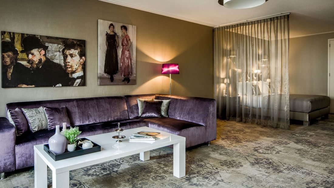 Cozy bed and sitting area with art on the wall Royal Suite at Luxury Suites Amsterdam
