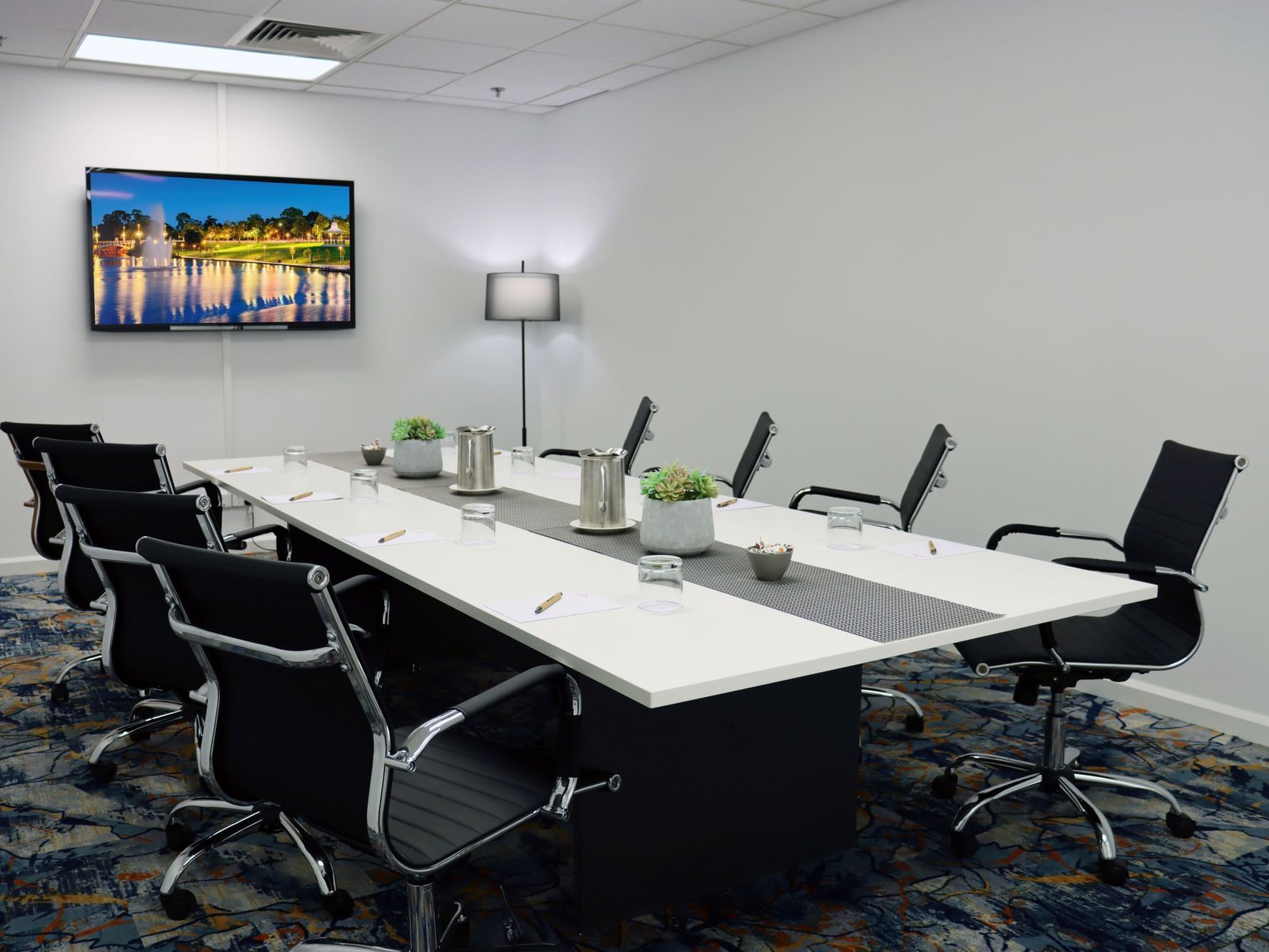 A large conference table surrounded by chairs in the West End Room 2 at Hotel Grand Chancellor Adelaide.