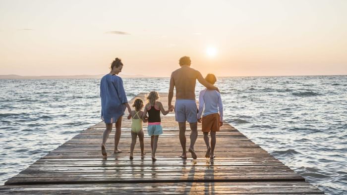 Family walking down a pier at the sea near Falkensteiner Hotels & Residences