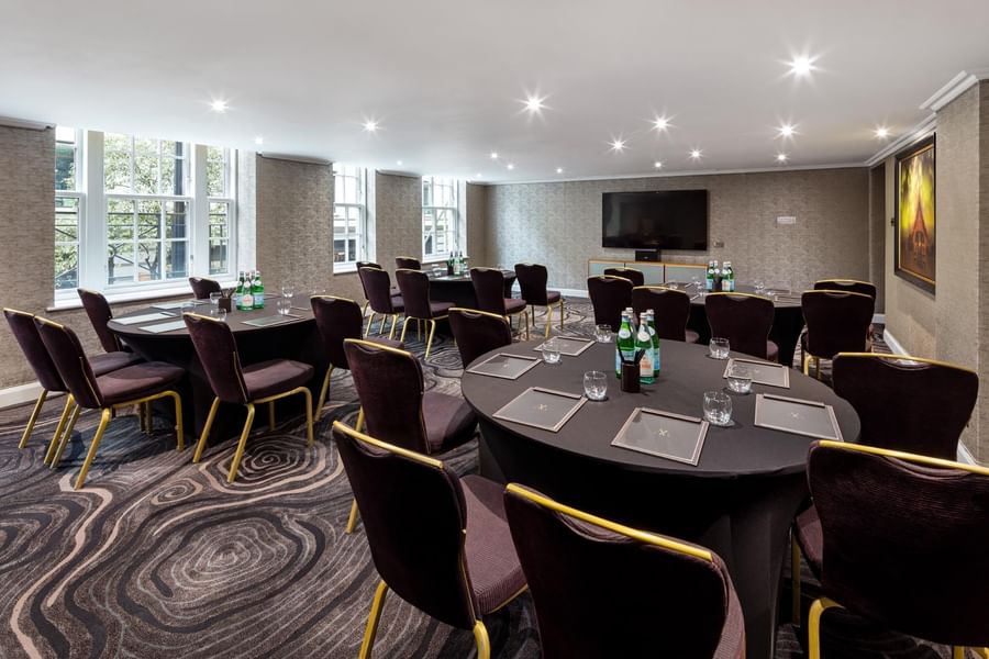 Cabaret-style meeting room with round tables and chairs arranged for small meetings at The May Fair Hotel, London