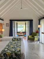 Two beds in a room with a balcony and ocean view at Warwick Le Lagon in Efate.