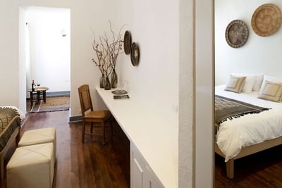 Suite with a long desk, wooden chair, & woven wall decor accented with branches at NOI Blend Colchagua, Valley