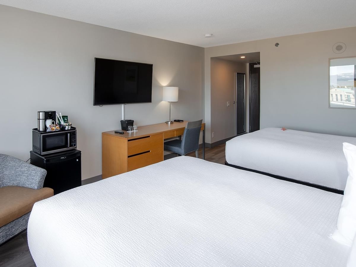 Hotel room with two queen beds, work desk, TV, mini fridge and microwave