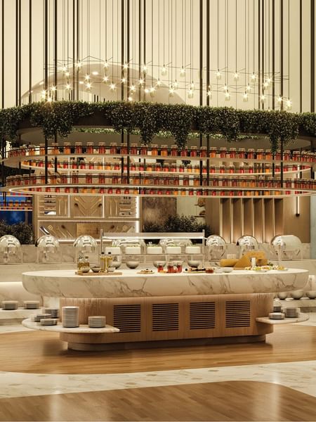 Marble buffet island by stacked plates under a hanging garden in The Med at Cantonal Hotel by Warwick Riyadh