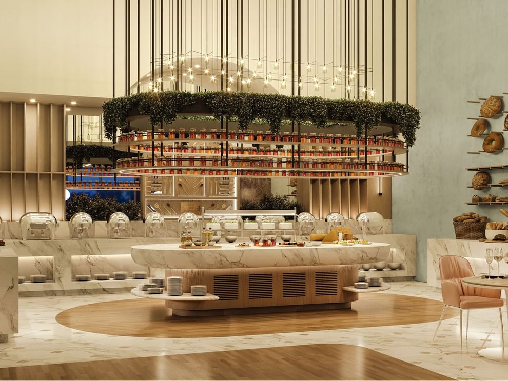 Marble buffet island by stacked plates under a hanging garden in The Med at Cantonal Hotel by Warwick Riyadh