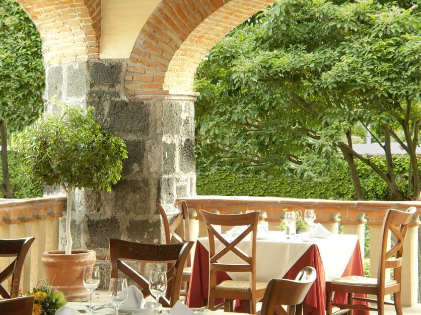 Restaurant's tables on a veranda facing a garden, La Colección