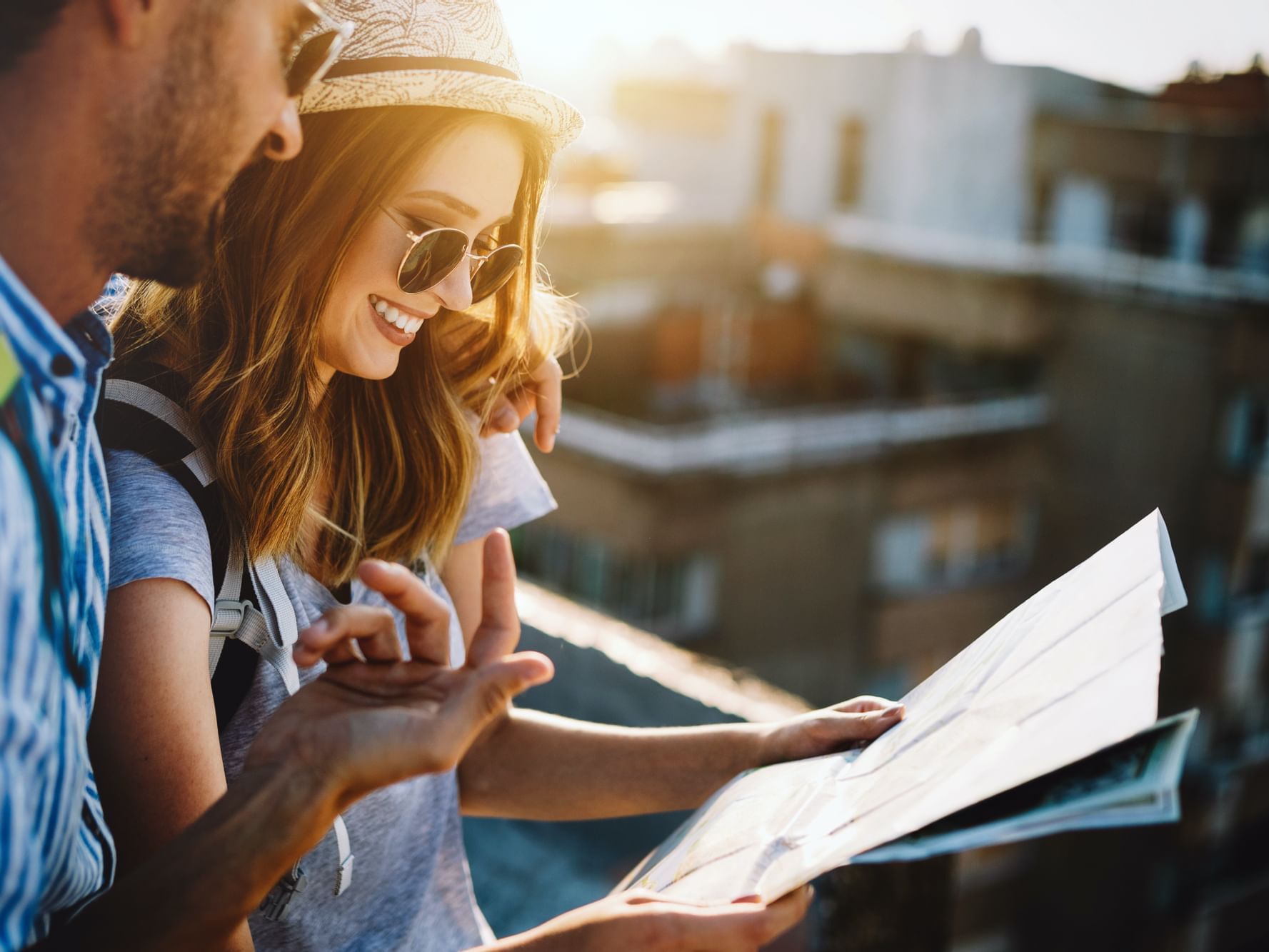 A couple looking at a map under the sunshine