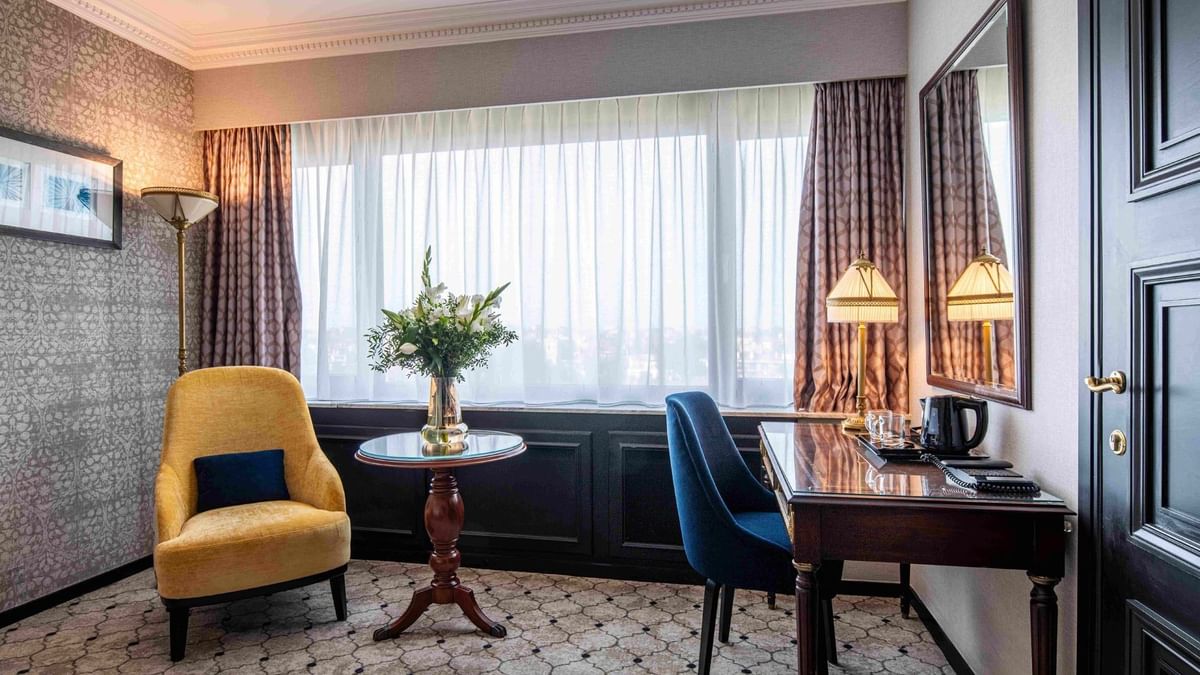 Elegante familiekamer met fauteuil en bureau in Hotel Barsey by Warwick Brussel.