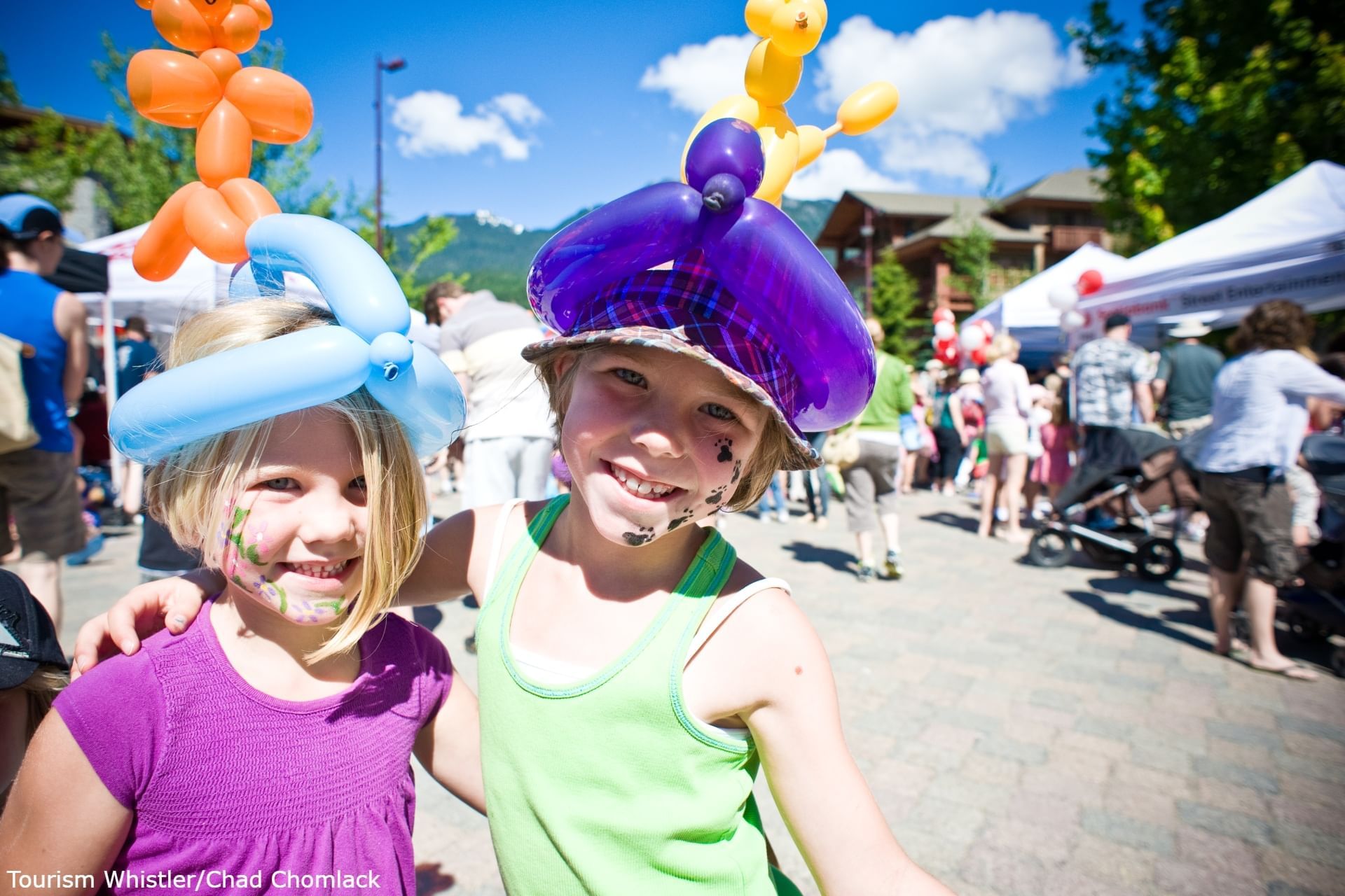 Happy kids posing by stalls in Whistler Children's Festival near Blackcomb Springs Suites