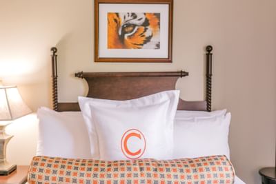 bed and pillow with the letter C and picture frame on the wall
