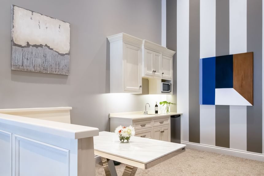 Kitchen area with pantry, paintings on the wall & dining table in Presidential suite at Retro Suites Hotel