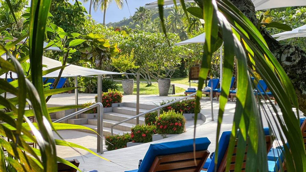 Blue sun loungers around a tropical pool at The Naviti Resort in Korolevu, Fiji.