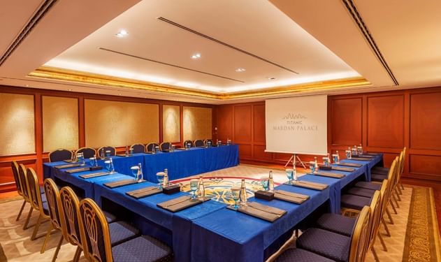 Titanic Deluxe Golf Belek'teki Convention Center'da U şeklinde masa düzeni ve projeksiyon perdesi.