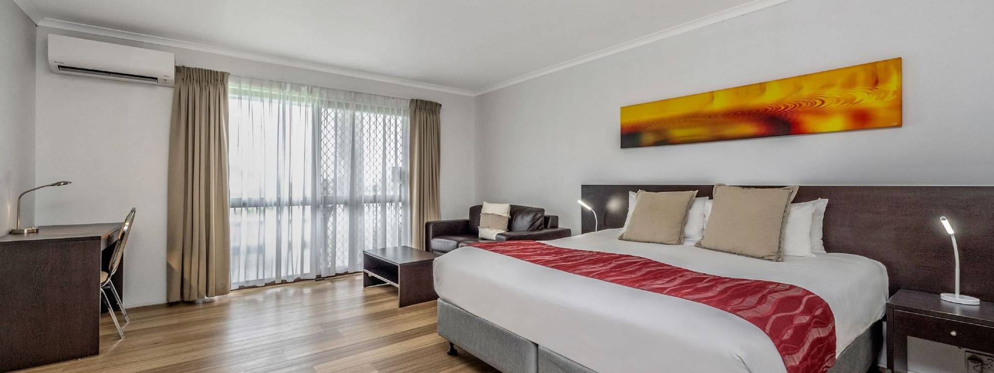 The Deluxe King Room invites you to relax with a luxurious King bed and a spacious lounge ae.