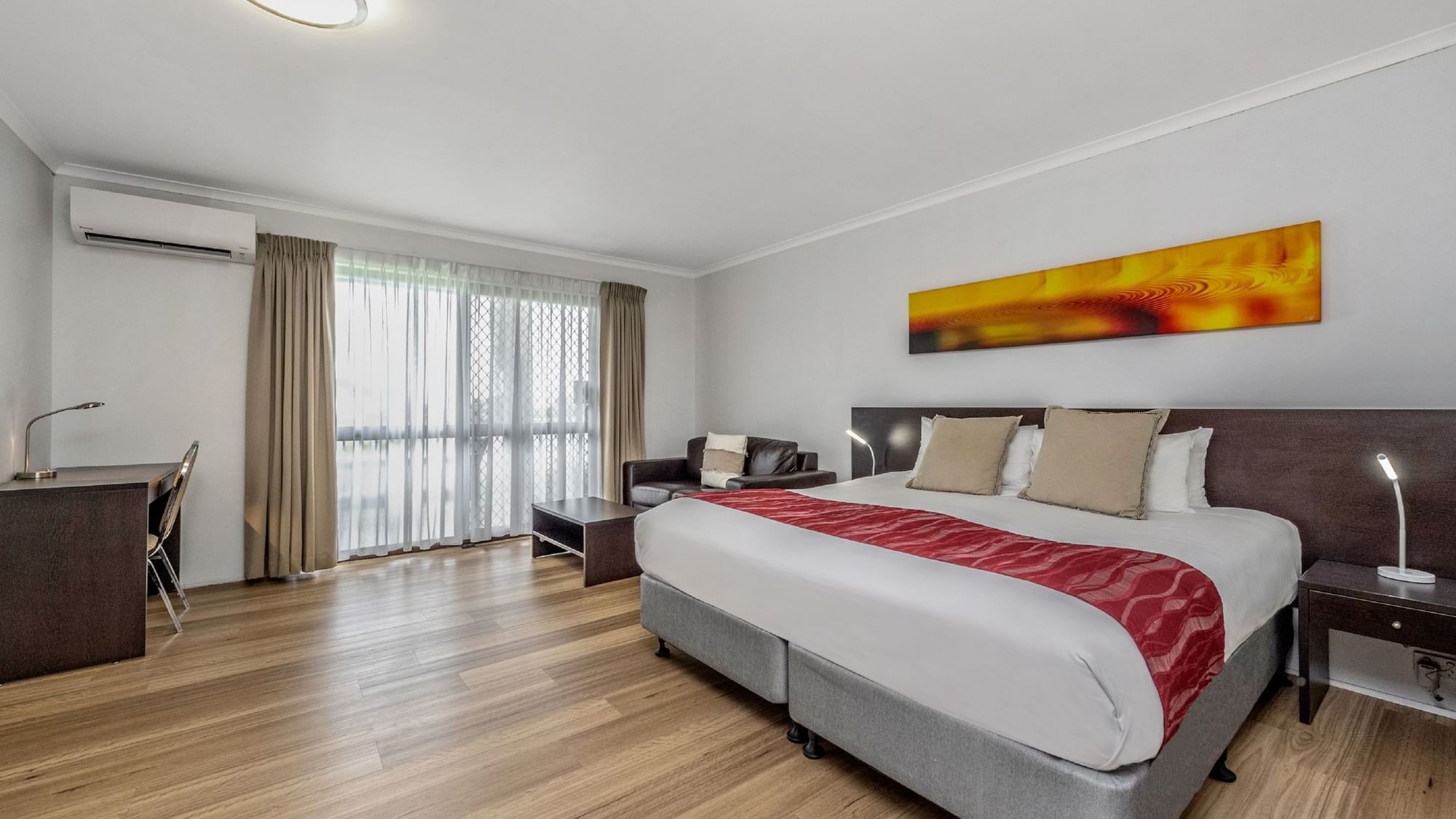 The Deluxe King Room invites you to relax with a luxurious King bed and a spacious lounge ae.