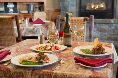 Dining room table with plates of food and wine glasses