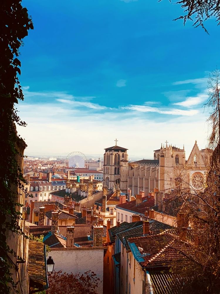 Cityscape of Lyon with view of a Ferris wheel & the prominent Gothic Saint-Jean Cathedral near Warwick Reine Astrid - Lyon