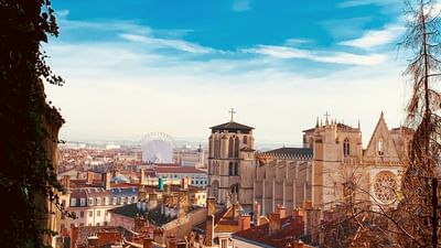 Cityscape of Lyon with view of a Ferris wheel & the prominent Gothic Saint-Jean Cathedral near Warwick Reine Astrid - Lyon
