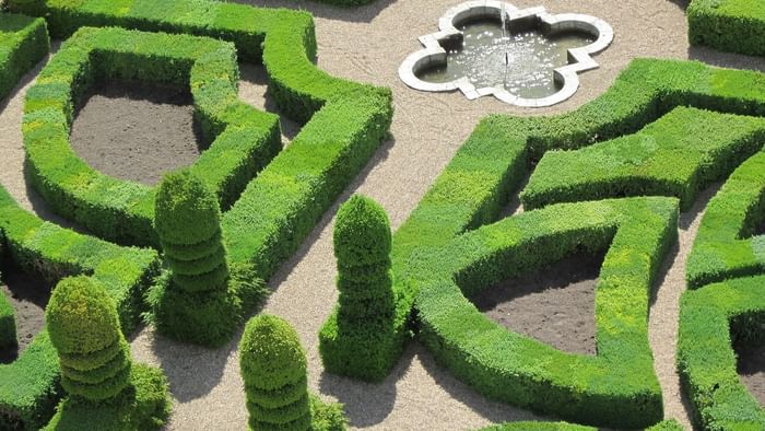 Garden with a water fountain at The Originals Hotels