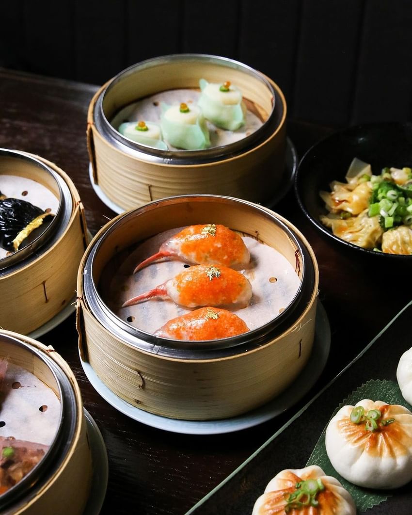 Steamed dim sum in bamboo steamers on a table at Paradox Vancouver