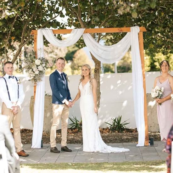 Wedding couple posing with the crew in the garden at Pullman Magenta Shores