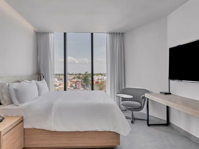Large bed & city view in Work Room 1 king at IOH Hotels