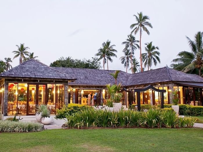 Meeting room by a green lawn under tall palm trees near the garden area at The Naviti Resort - Fiji