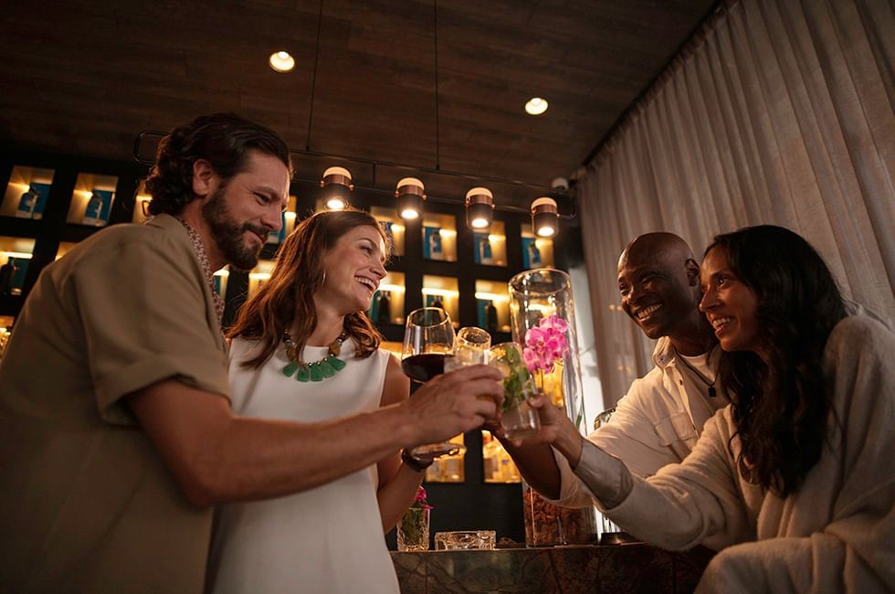 People are toasting with drinks in bar at Live Aqua Resorts and Residence Club