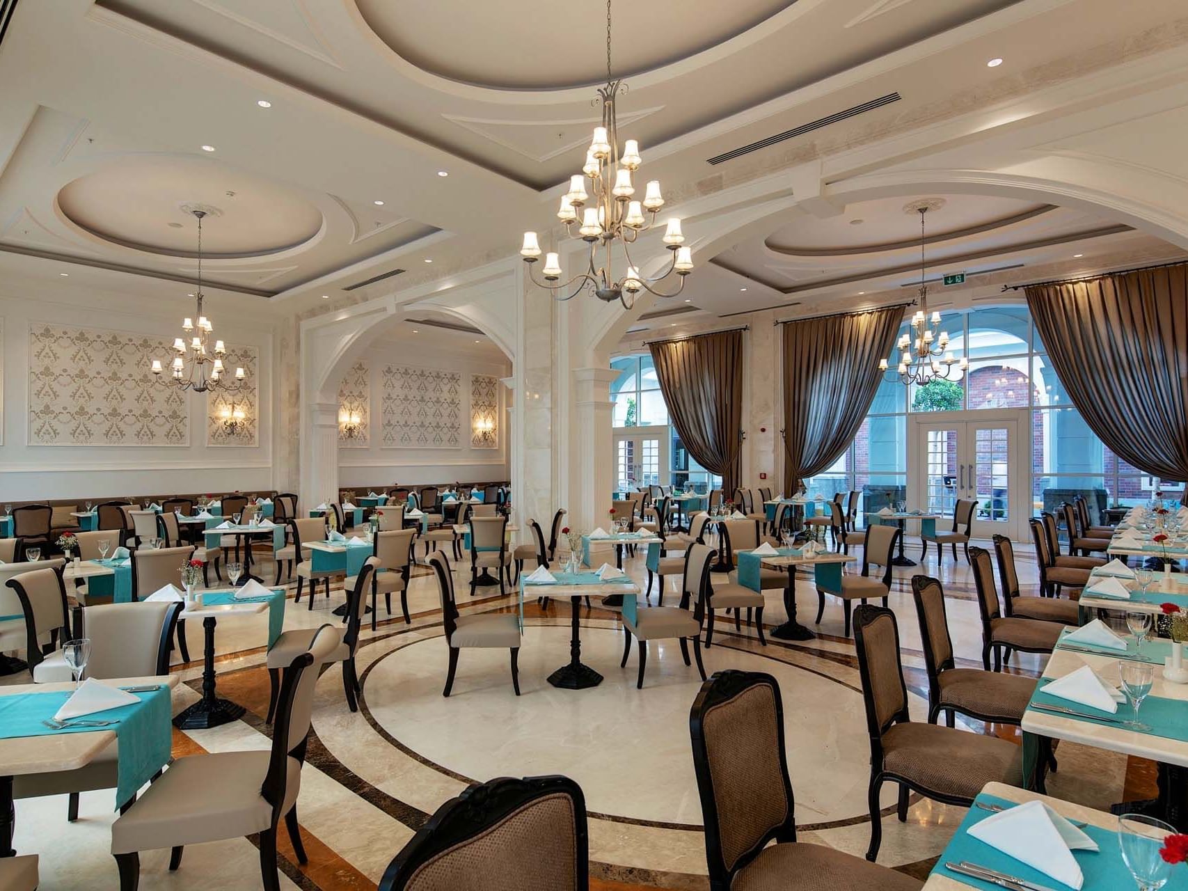 Dining tables arranged with chairs in Classico Main Restaurant at Titanic Deluxe Golf Belek