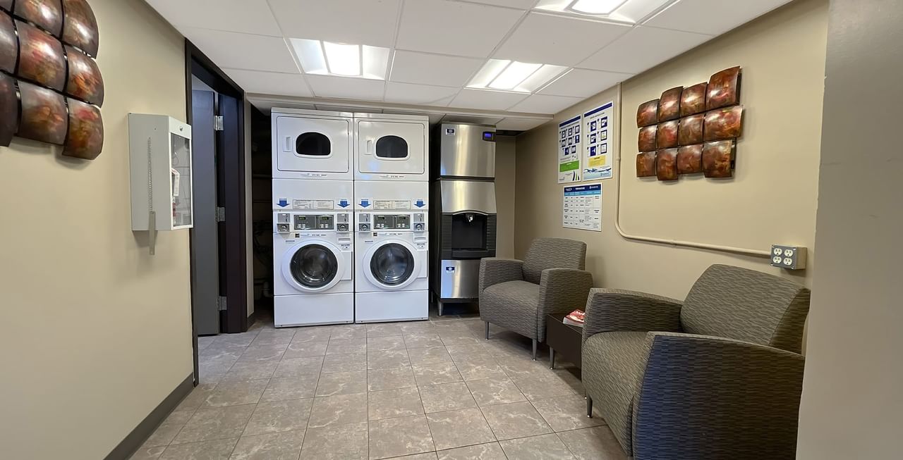 guest laundry room with washing machine, ice machine and sitting area