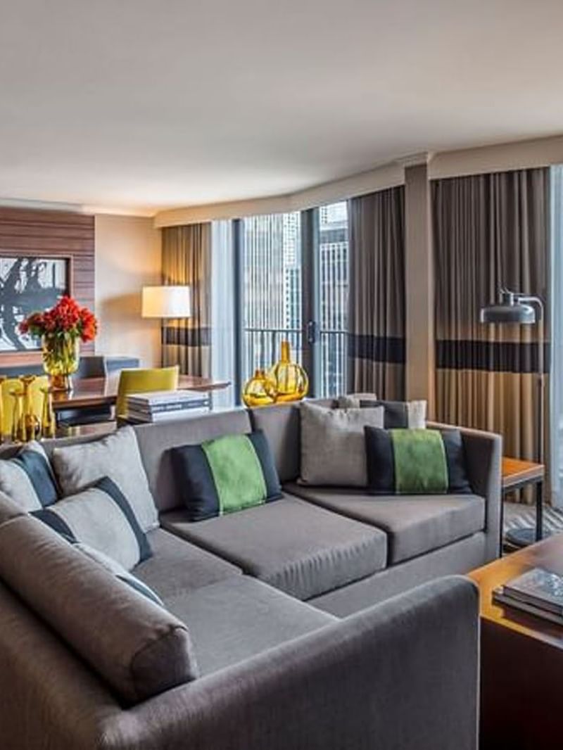 Large grey sectional sofa by a wooden coffee table in a modern living area in Emerald Suite at Warwick Seattle