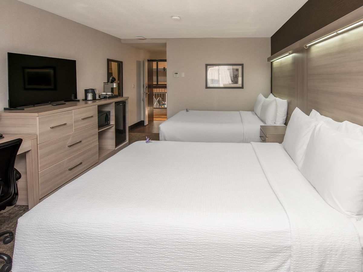 Coast Premium Two Queens room with two queen beds, modern furnishings, and work desk at Coast Calgary University Area Hotel by APA