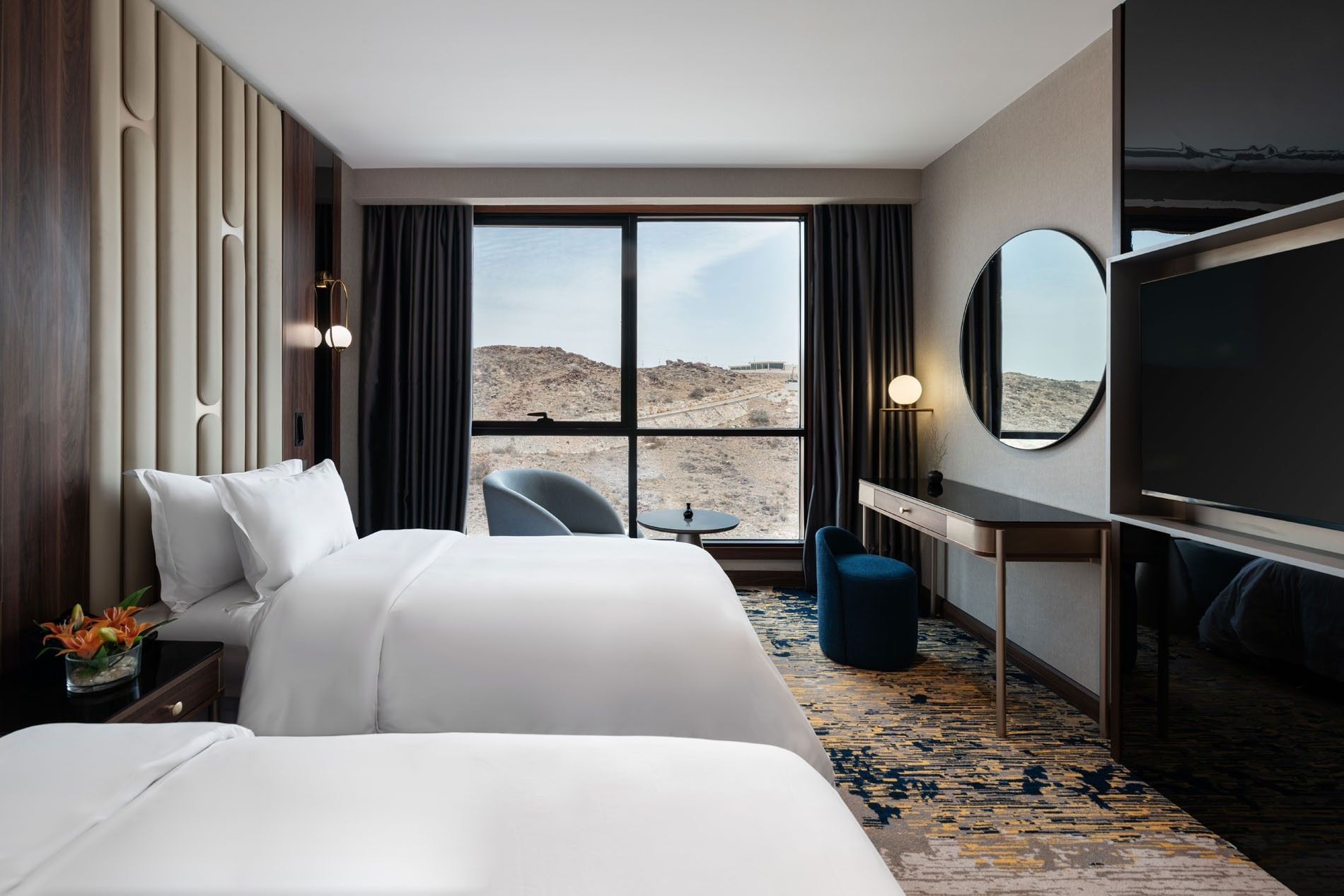TV facing two beds with a work desk by the window in Royal Suite at Warwick Al Taif Hotel