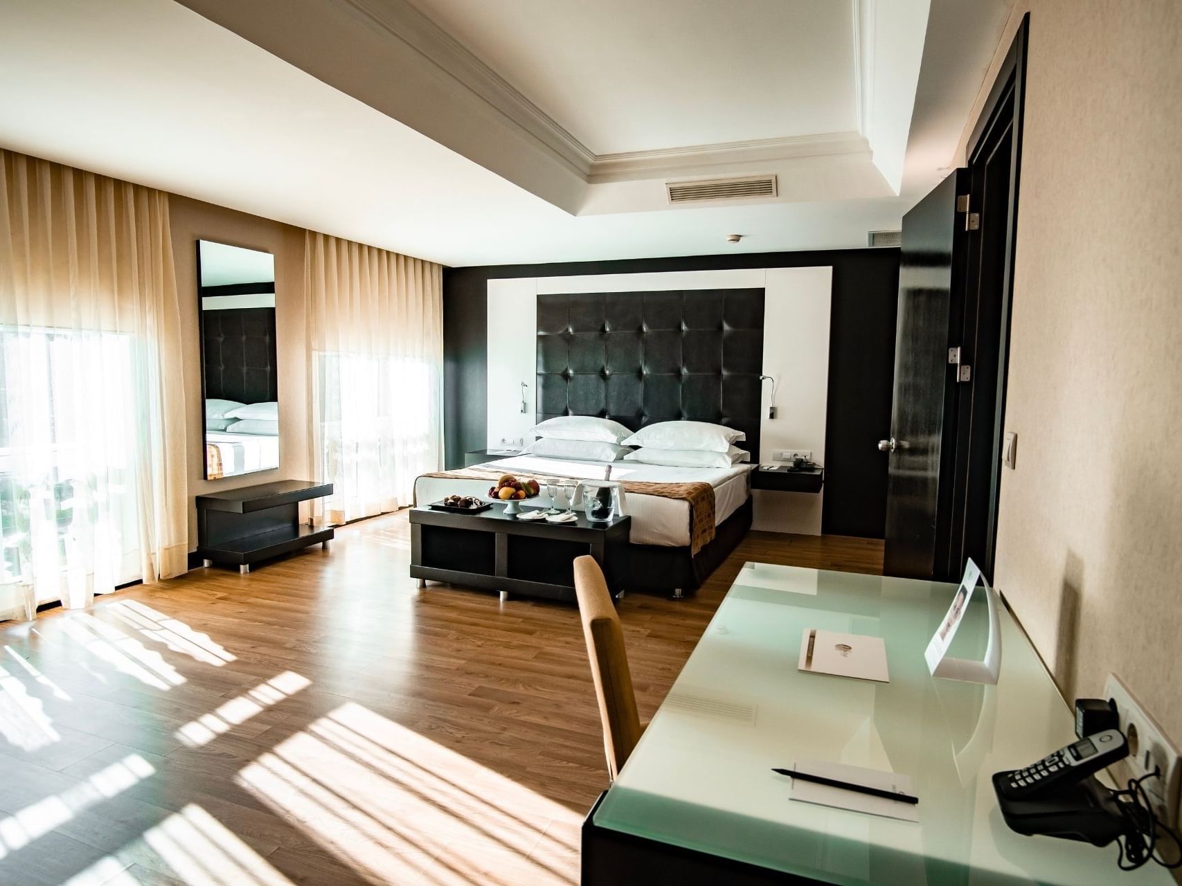 Spacious senior suite bedroom with modern decor, large windows, and cozy seating at Eresin Hotels Topkapı, Istanbul.