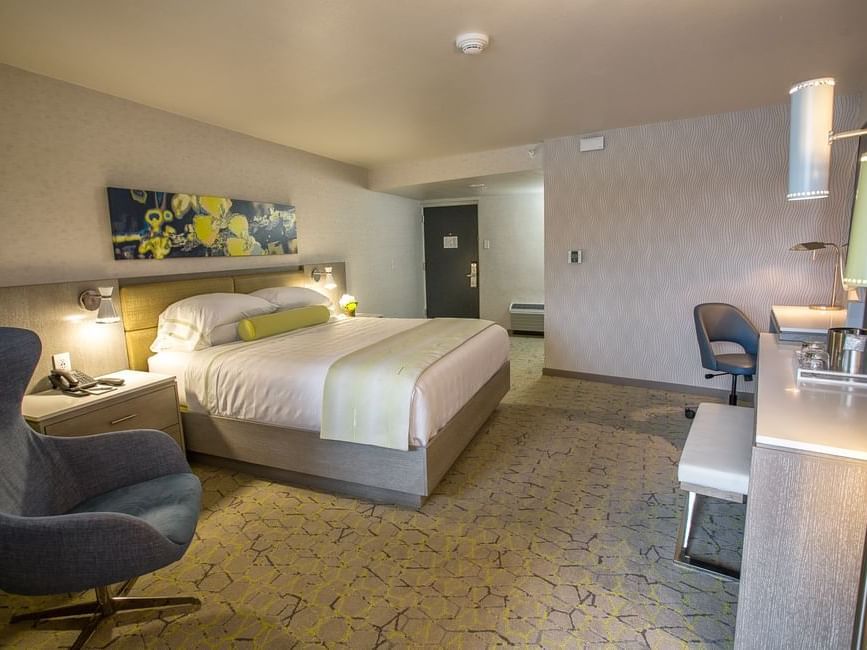 a chair, bed, and desk in a hotel room