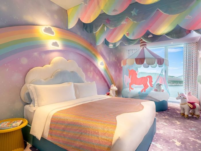 Comfy bed and sitting area in Rainbow Unicorn Room at Fullerton Ocean Park Hotel Hong Kong