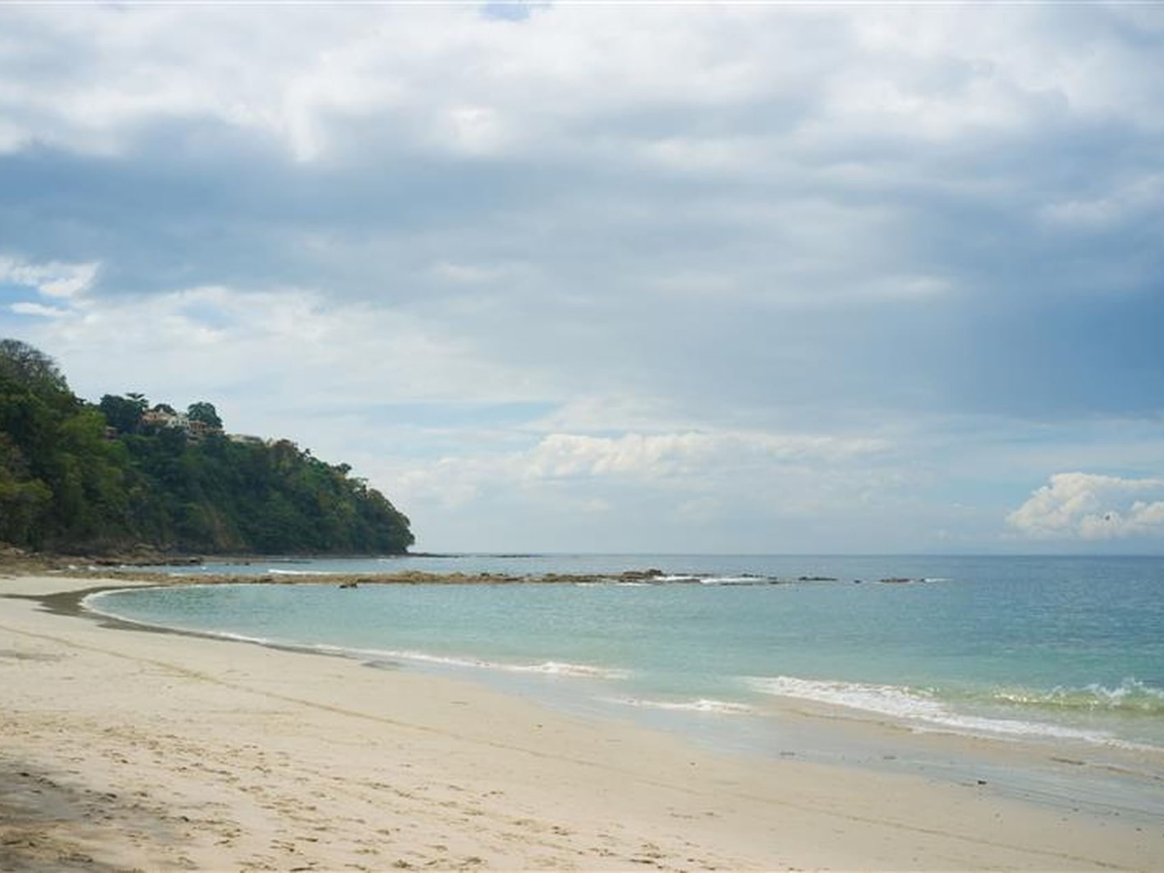 Sandy beach cove curving to rocky outcropping & hillside near Santa Lucia Jungle Hacienda, Puntarenas Costa Rica hotels