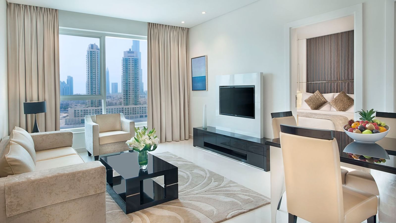Living area and dining area with city view in One Bedroom Suite at DAMAC Maison Canal Views