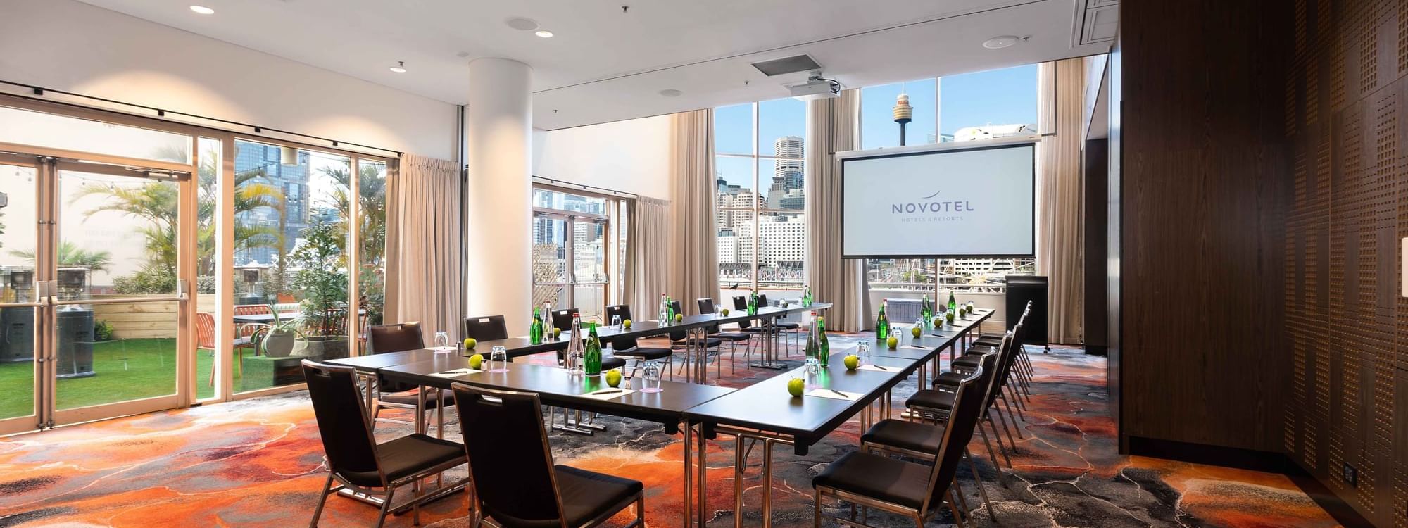 U-shape table set-up facing the projector screen in The Hunter Room 1-2 at Novotel Sydney on Darling Harbour