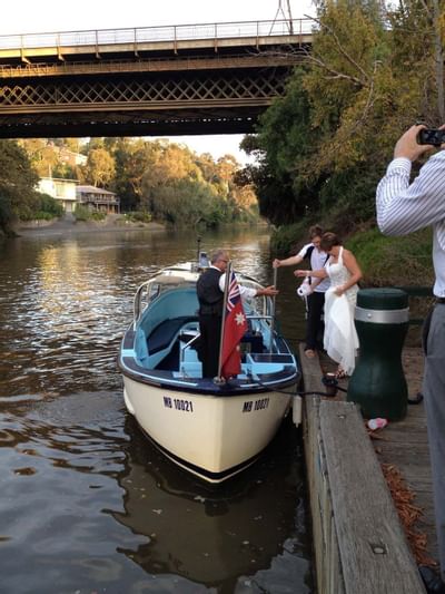 A bride getting on a boat, by a bridge at Amora Hotel