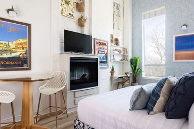 Cozy bed, fireplace, sitting area & wall pictures in Superior Loft at Retro Suites Hotel