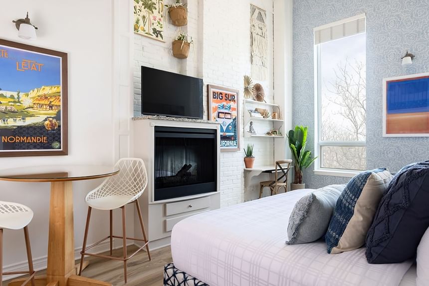 Cozy bed, fireplace, sitting area & wall pictures in Superior Loft at Retro Suites Hotel